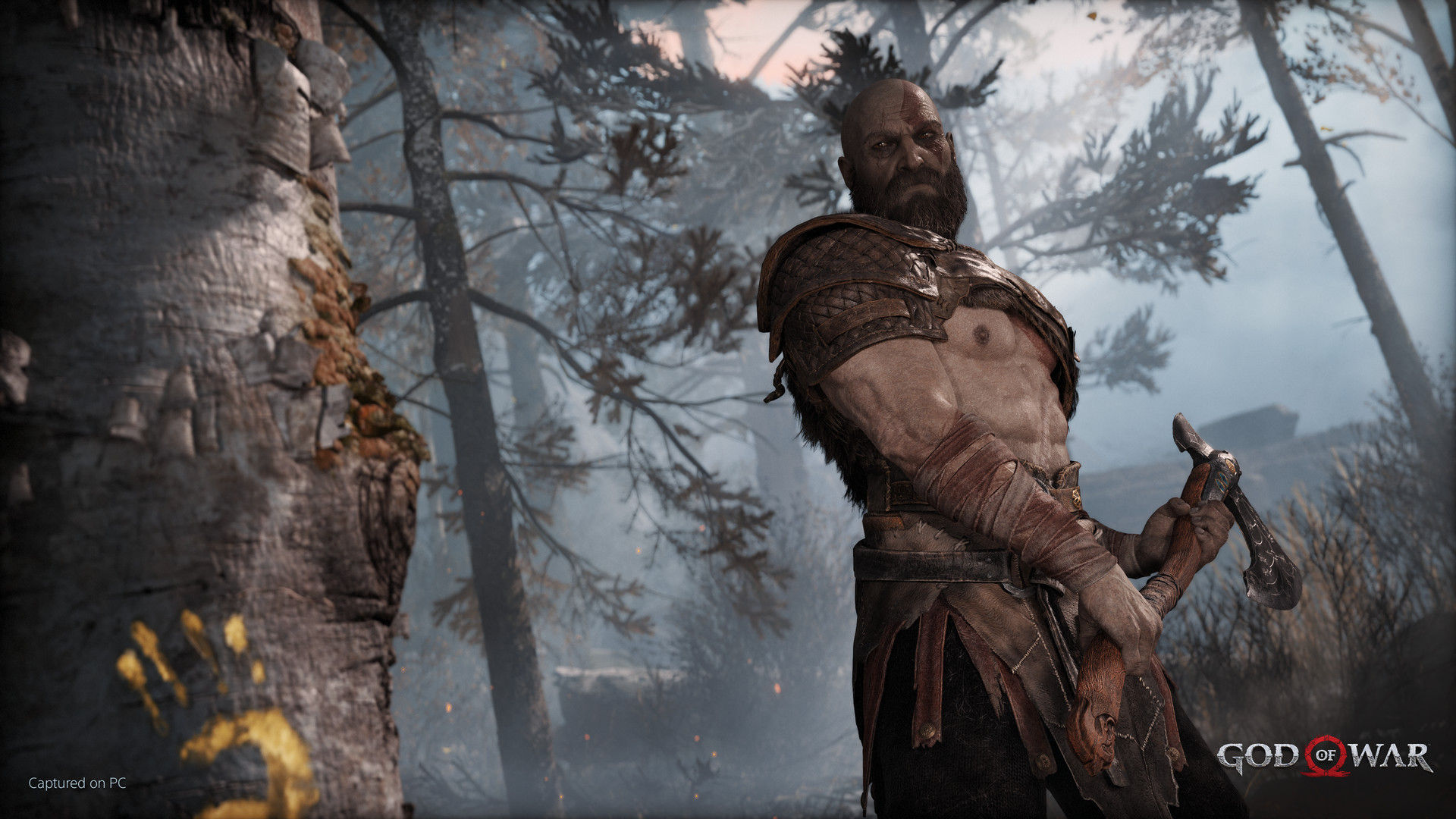 Kratos in a snowy forest in God of War.